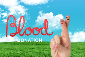 Blood donation against green field under blue sky