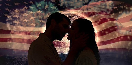 Attractive young couple about to kiss against colourful fireworks exploding on black background