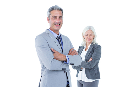 Smiling businesswoman and man with their arms crossed against a white background