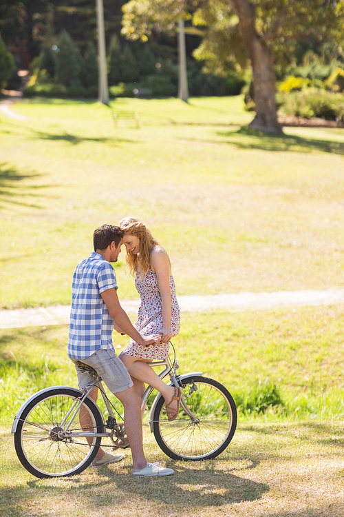 Young couple on a bike ride in the park on a sunny day