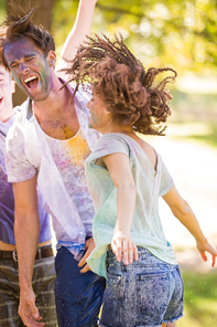 Young friends having fun with powder paint on a sunny day