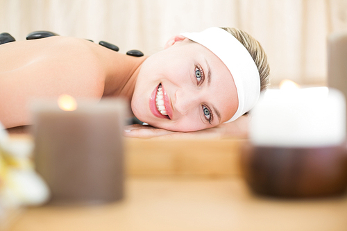 Beautiful blonde enjoying a hot stone massage at the health spa