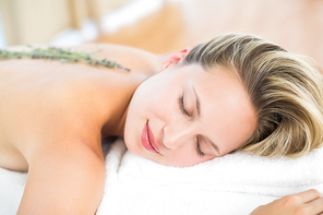 Beautiful blonde lying on massage table with lavanda at the health spa