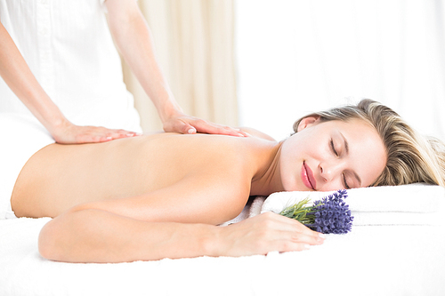 Beautiful blonde lying on massage table with lavanda at the health spa