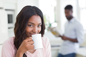 Pretty woman having cup of coffee at home in the kitchen