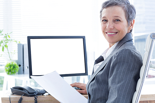 Smiling businesswoman using computer at the office