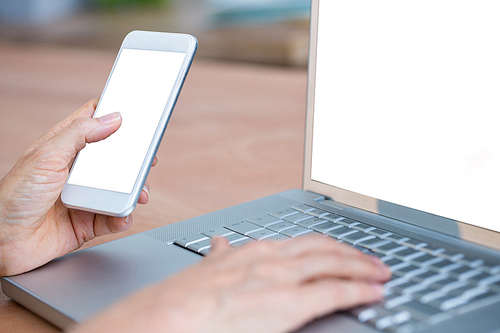 Close up view of hands typing on laptop and texting