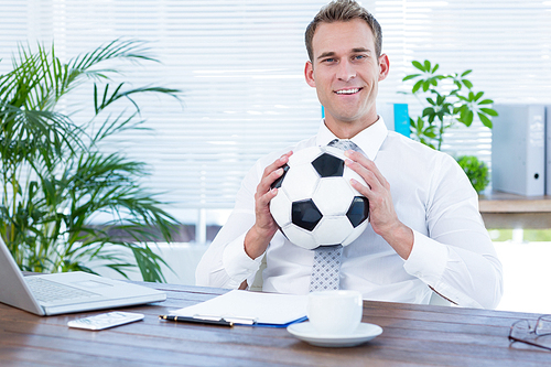 Portrait of a smiling businessman holding a football