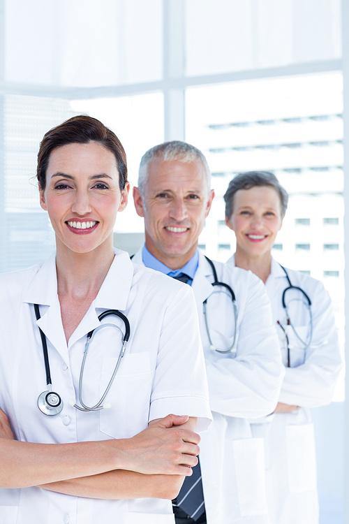 Portrait of three smiling medical colleagues with arms crossed in the hospital