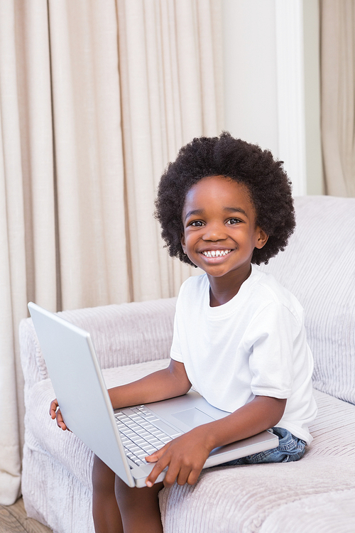 Portrait of a little boy using a laptop at home on the living room