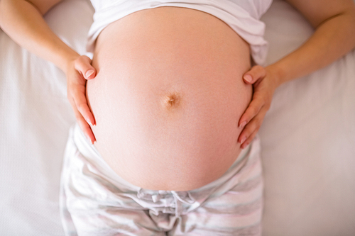 Close up view of pregnant woman belly at home