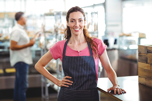 Pretty waitress leaning on counter at the bakery