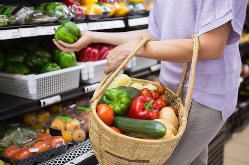 Smiling pretty blonde woman buying products at supermarket