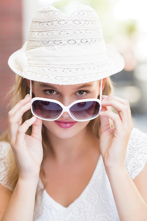 Portrait of a pretty woman tilting her sunglasses