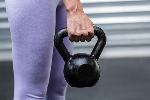 Close up view of hands holding kettlebells at the crossfit gym