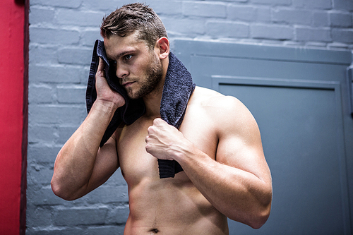 Muscular man with a towel in crossfit gym