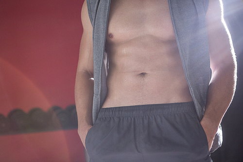 Muscular man with hands in his pocket in crossfit gym