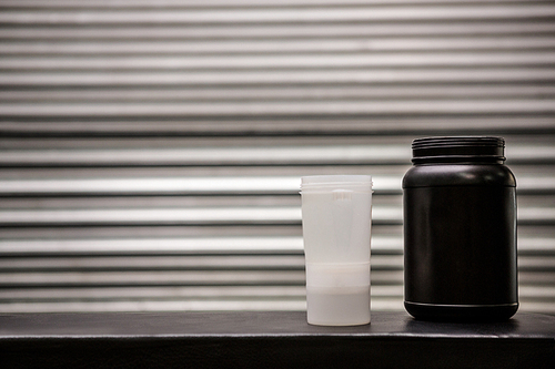 Protein powder drink and flask in crossfit gym