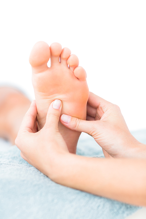 Close-up of a young woman receiving foot massage at spa center