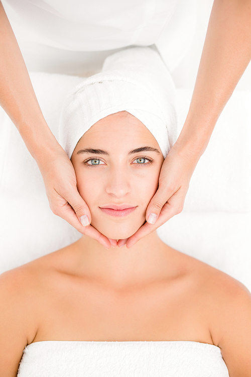 High angle view of an attractive young woman receiving facial massage at spa center