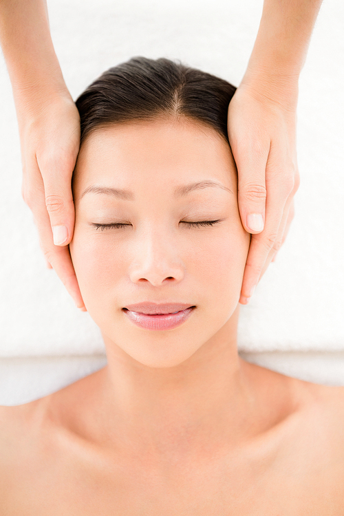 Attractive young woman receiving head masage at spa center