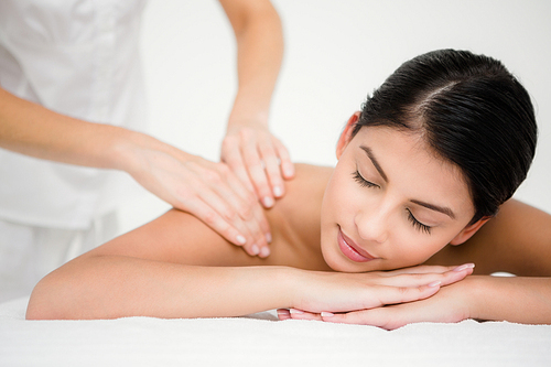 Pretty brunette enjoying a massage at the health spa