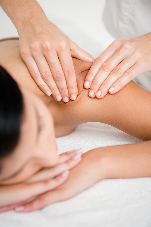 Pretty brunette enjoying a massage at the health spa