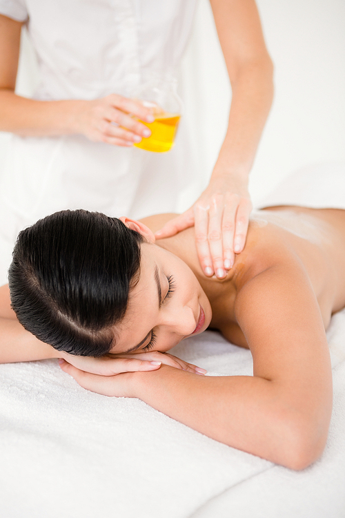 Beautiful woman enjoying oil massage at beauty spa