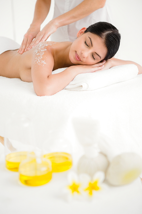 Woman enjoying a salt scrub massage at the health spa