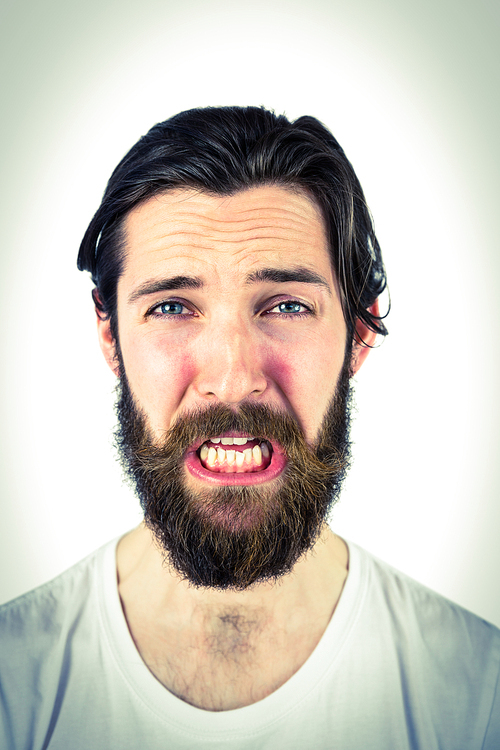 Handsome hipster crying at camera on vignette background