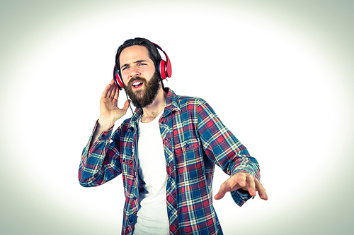 Handsome hipster enjoying listening to music on vignette background