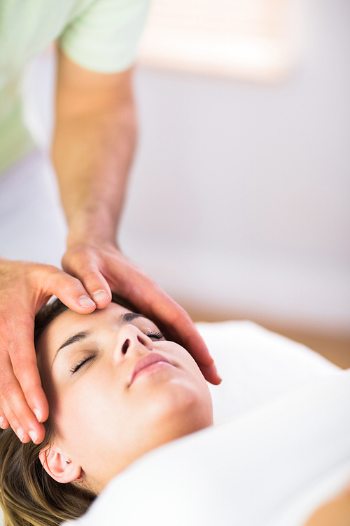 Relaxed pregnant woman getting reiki treatment in a studio