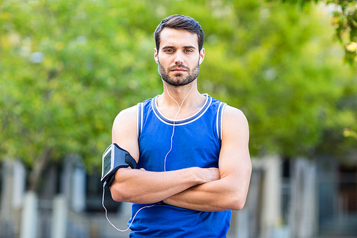 Portrait of an handsome athlete looking at the time on a sunny day