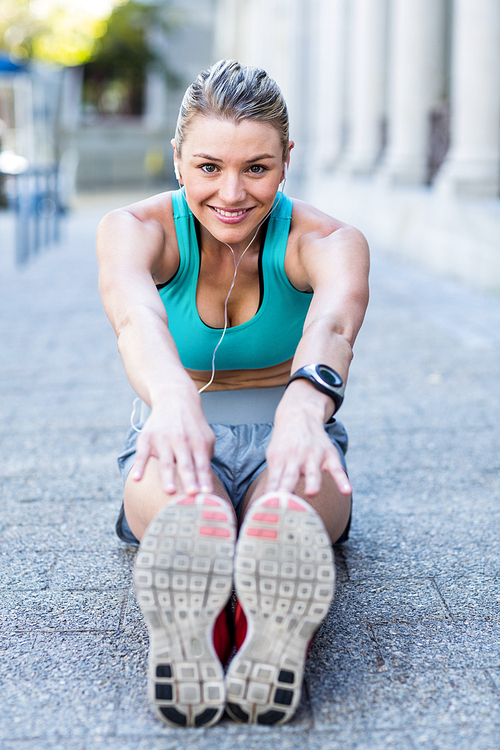 A beautiful woman stretching her leg on a sunny day