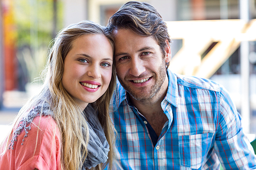 Smiling couple having tea in a cafe on a sunny day