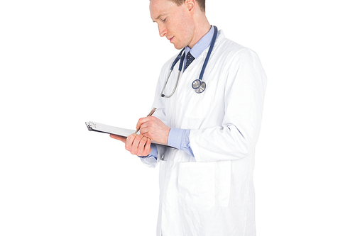 Serious doctor writing on a clipboard against a white background