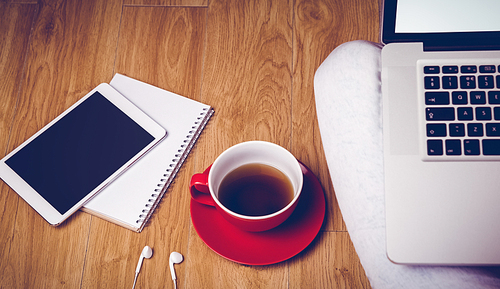 Overhead shot of laptop, tablet, coffee and headphones on the floor