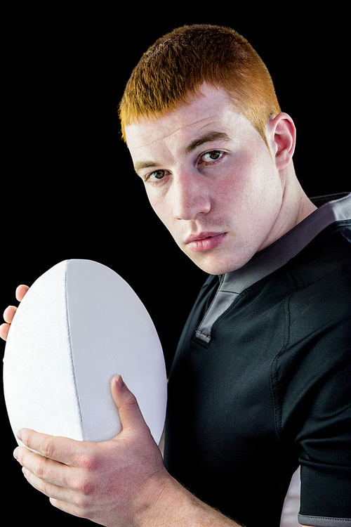 Profile view of a rugby player holding a rugby ball