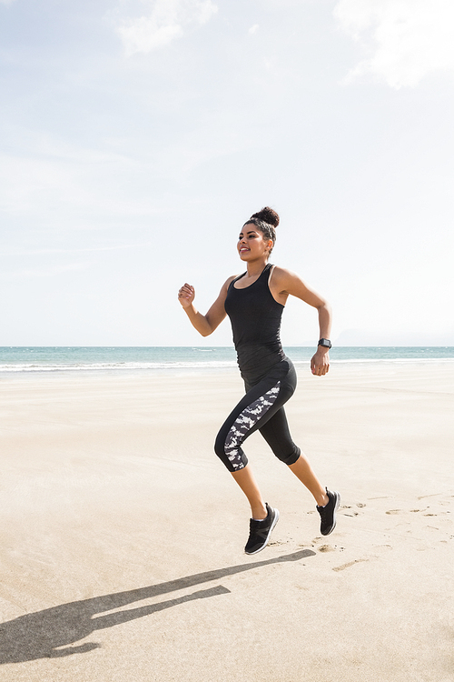 Fit woman jogging on the sand at the beach
