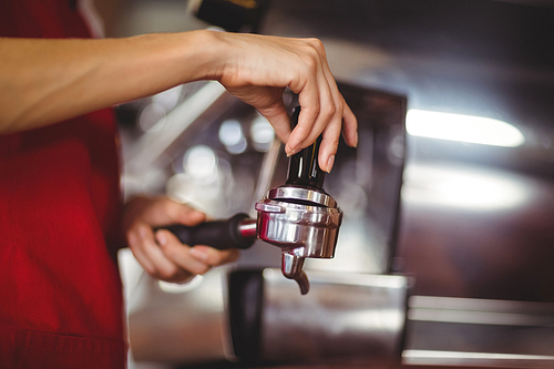 Close up view of a barista pressing coffee at the coffee shop