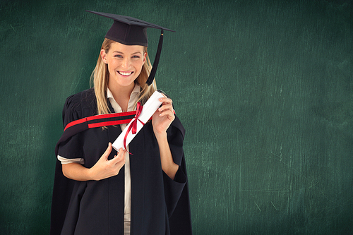 Woman smiling at her graduation  against green chalkboard