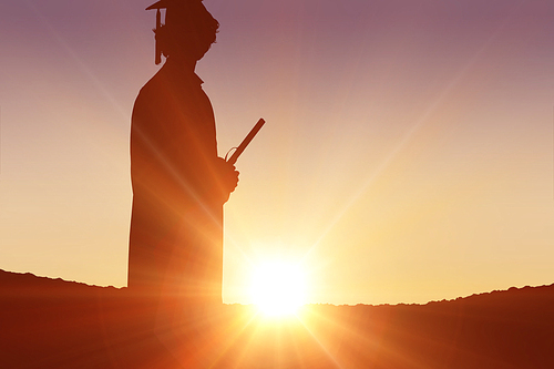 Silhouette of graduate against sun shining
