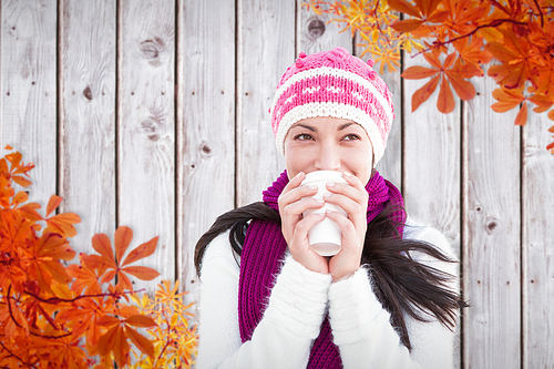 Composite image of winter brunette with coffee