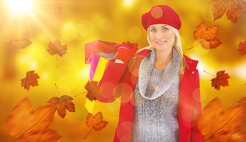 Composite image of blonde in winter clothes holding shopping bags
