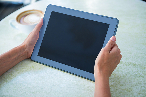 Woman using tablet on cafe terrace on a sunny day