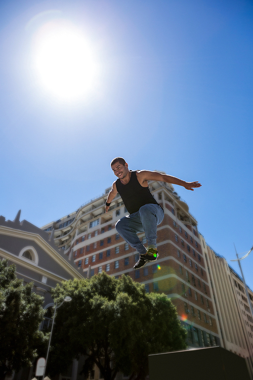 Athletic man doing parkour in the city on a sunny day