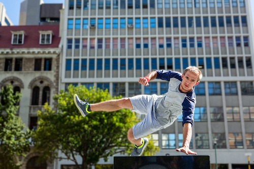 Man doing parkour in the city on a sunny day