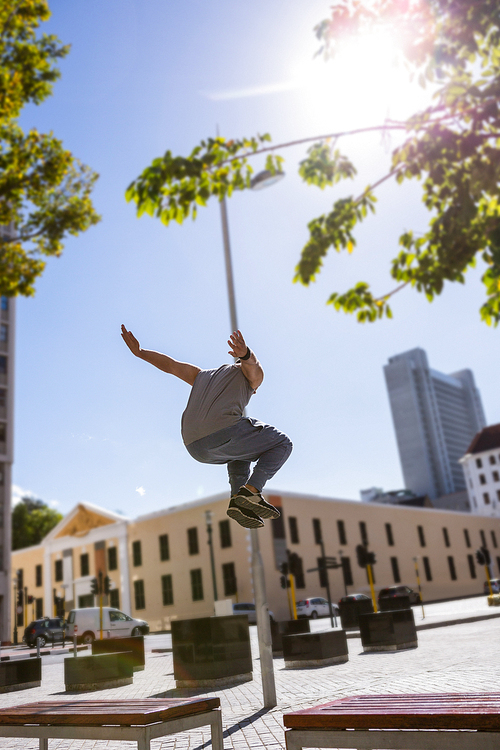 Man doing parkour in the city on a sunny day