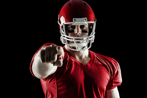 American football player pointing at camera on black background