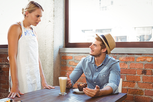 Handsome hipster talking to blonde waitress at coffee shop